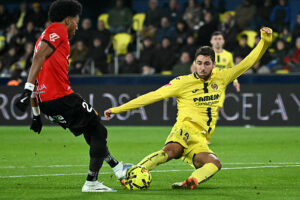Villarreal's Spanish midfielder #14 Santi Comesana fights for the ball with Real Mallorca's Colombian defender #22 Johan Mojica during the Spanish league football match between Villarreal CF and RCD Mallorca at La Ceramica Stadium in Vila-real on November 22, 2025. (Photo by JOSE JORDAN / AFP via Getty Images)
